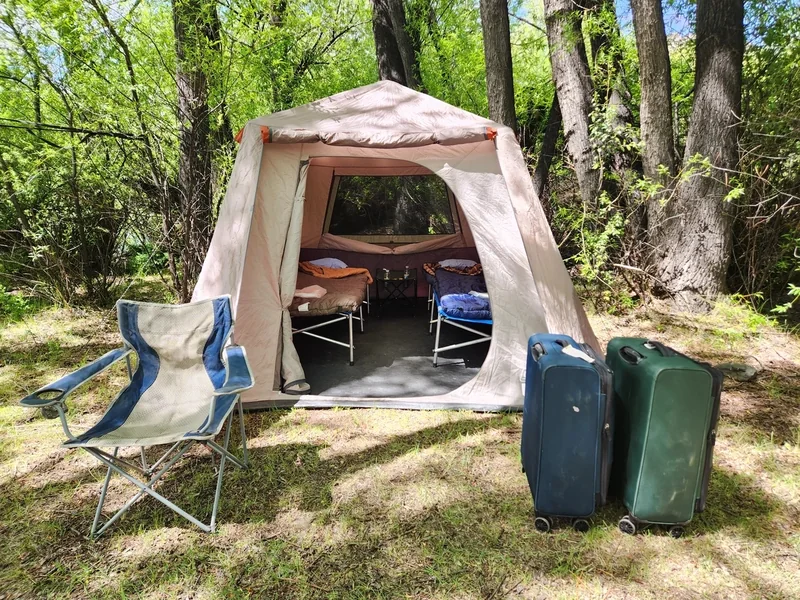 Bolsos estancos junto a una carpa para dormir en un campamento de pesca