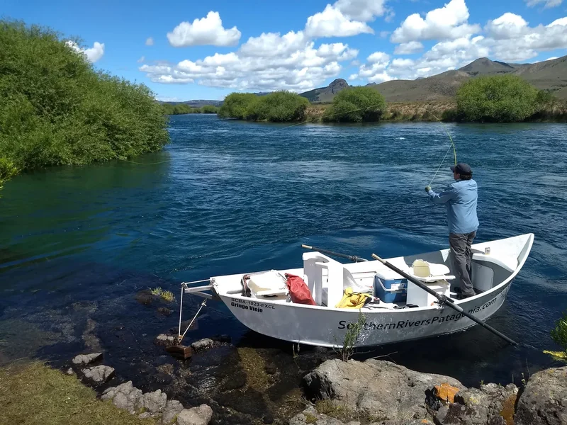 Un pescador lanza una mosca desde un bote en el río Limay durante una salida de pesca cerca de Bariloche, Patagonia