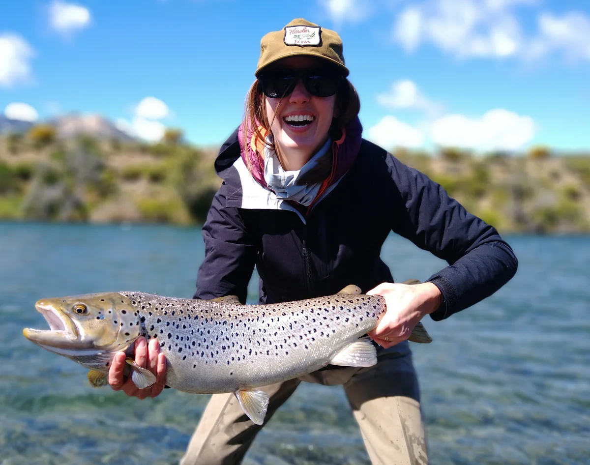 Happy angler holding a brown trout on a fly fishing holiday in Bariloche, Patagonia