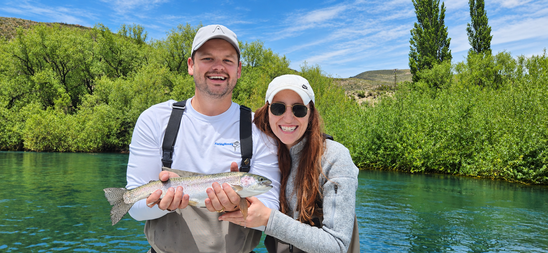 Couple holding a rainbow trout during a guided fly fishing day trip in Patagonia