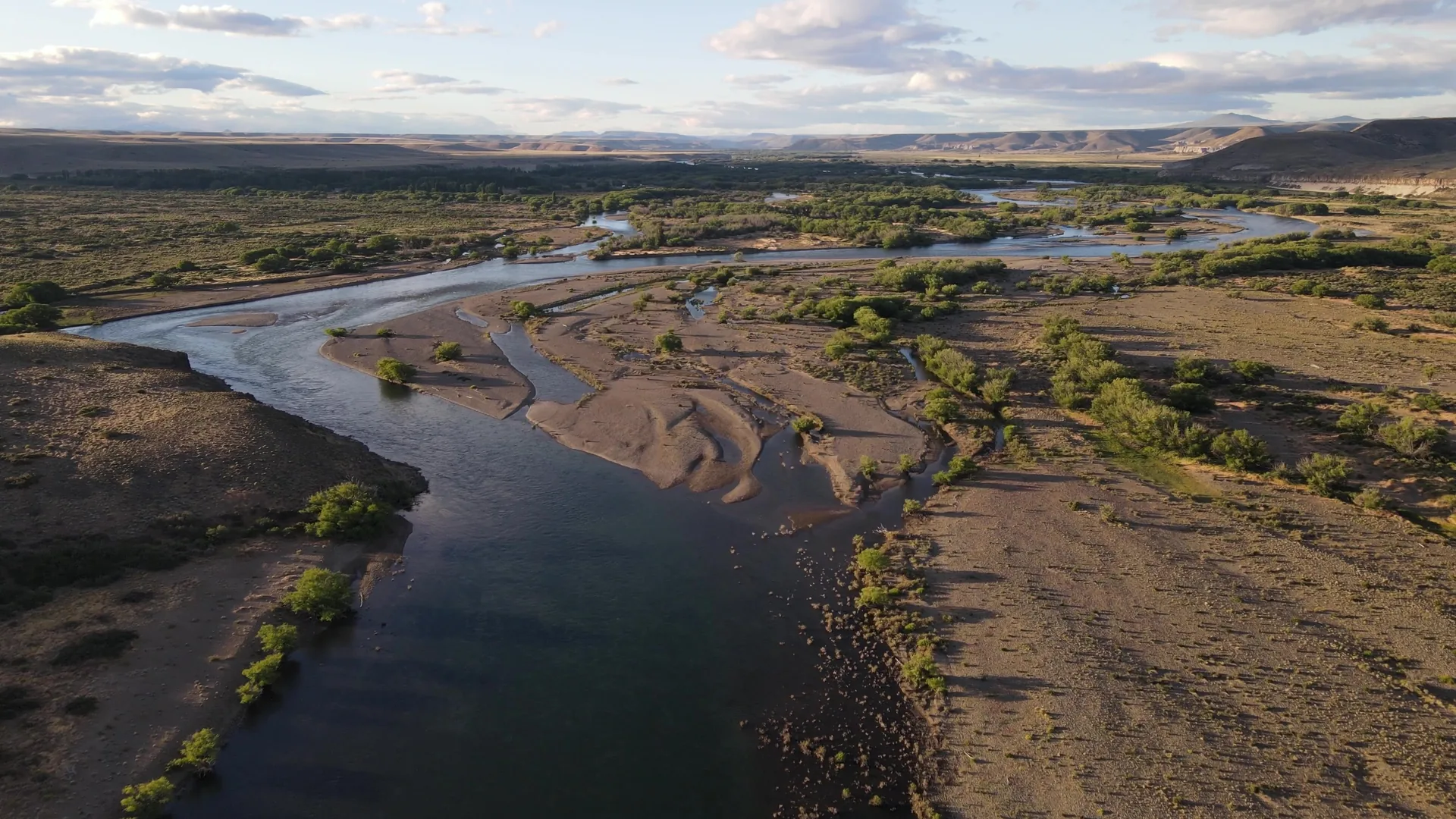 Panoramic view of the Collón Cura River winding through Patagonia’s steppe