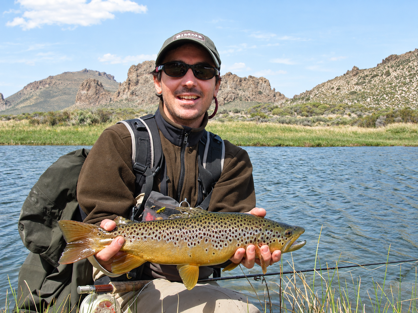 Angler holding a brown trout on the Pichi Leufú River during a guided fly fishing trip near Bariloche, Patagonia