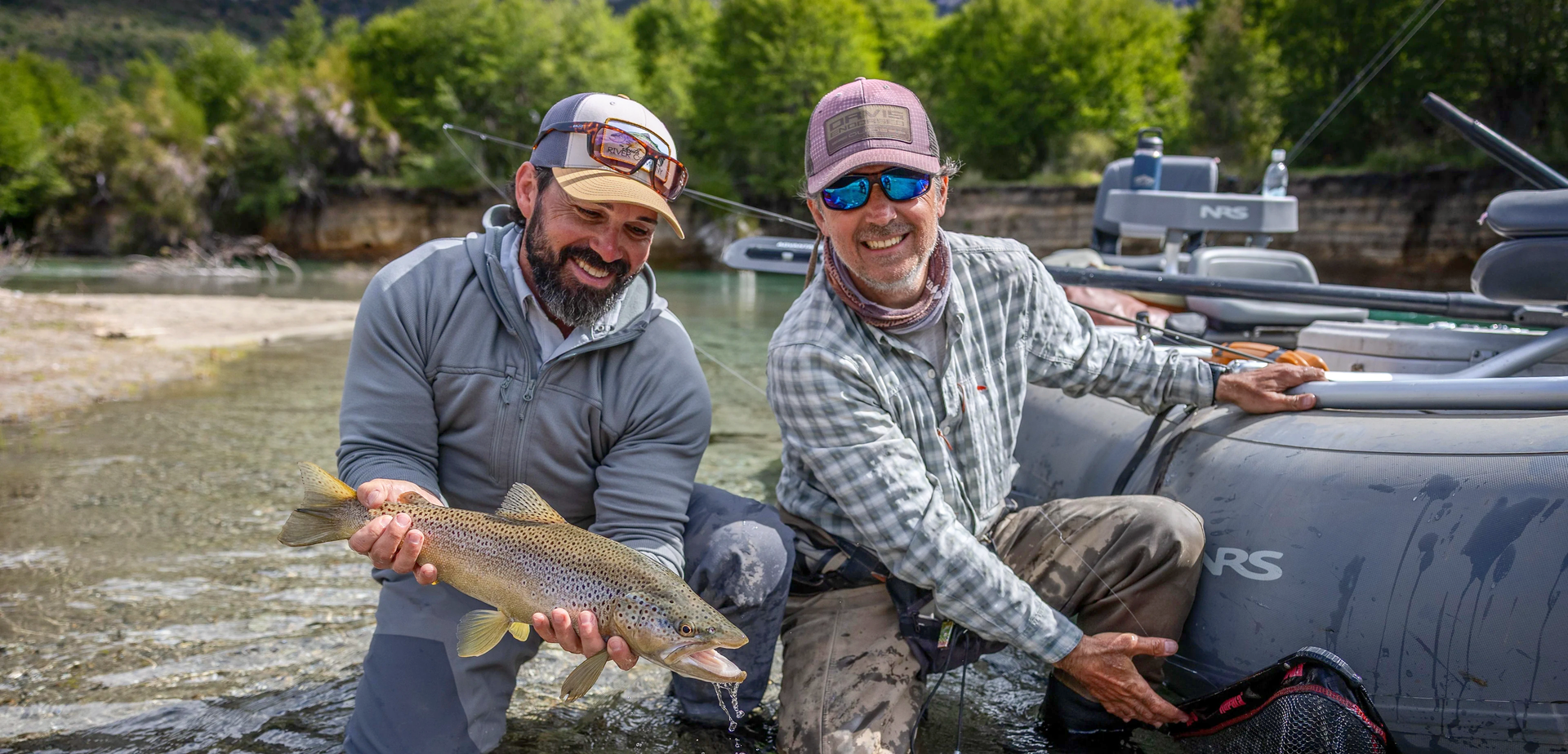Lucas Valenti junto a un cliente con una trucha marrón en el río Manso, cerca de Bariloche, Patagonia
