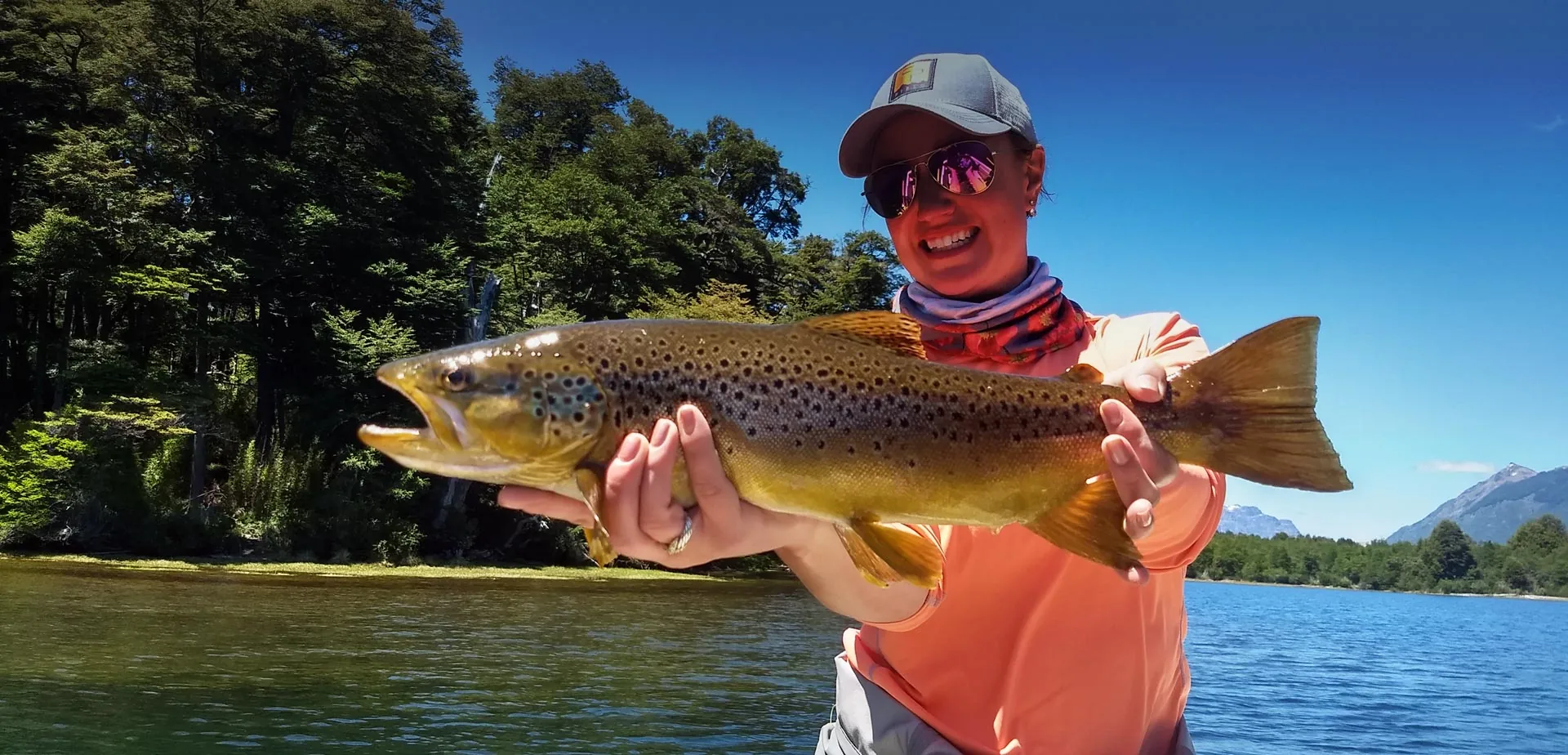 Angler holding a brown trout on a guided fly fishing trip near Bariloche, Patagonia