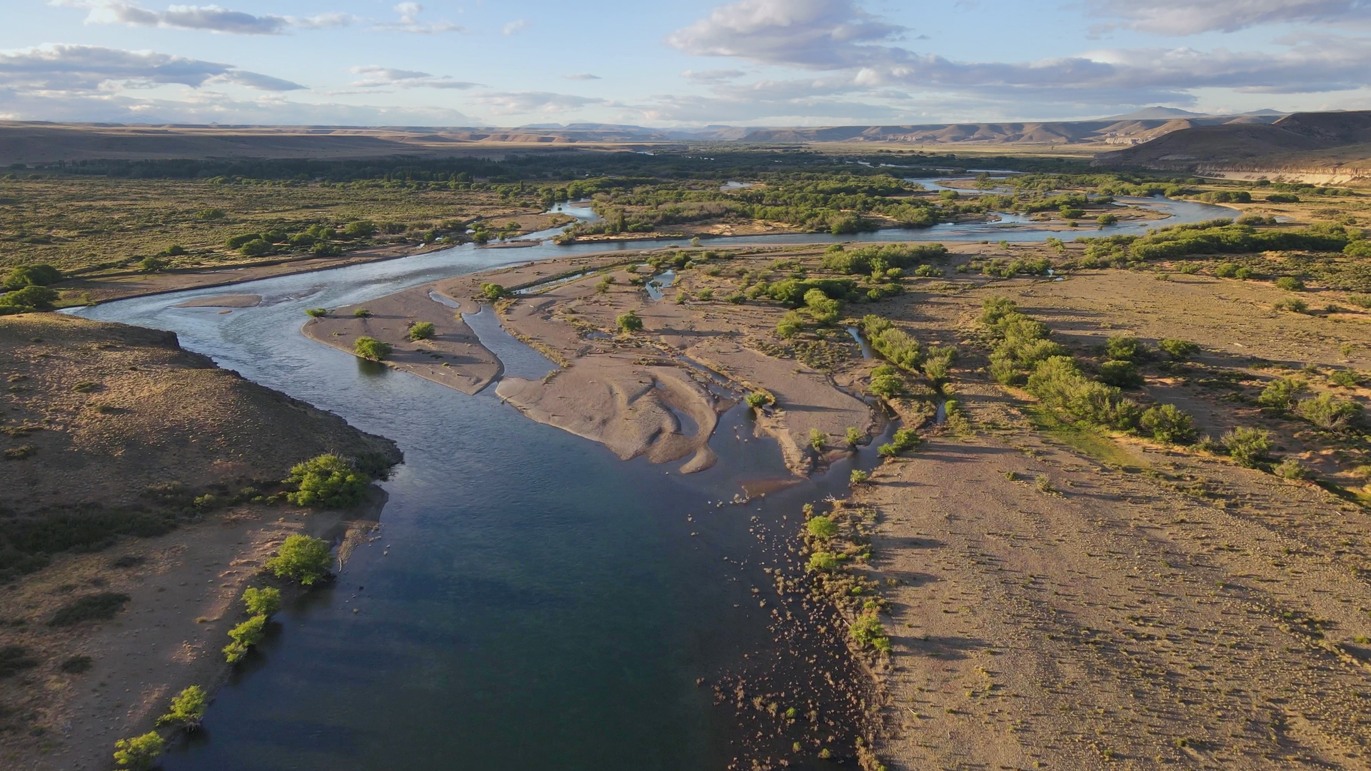 Panoramic view of the Collón Cura River and its side channels in the Patagonian steppe, a destination for fly fishing expeditions.