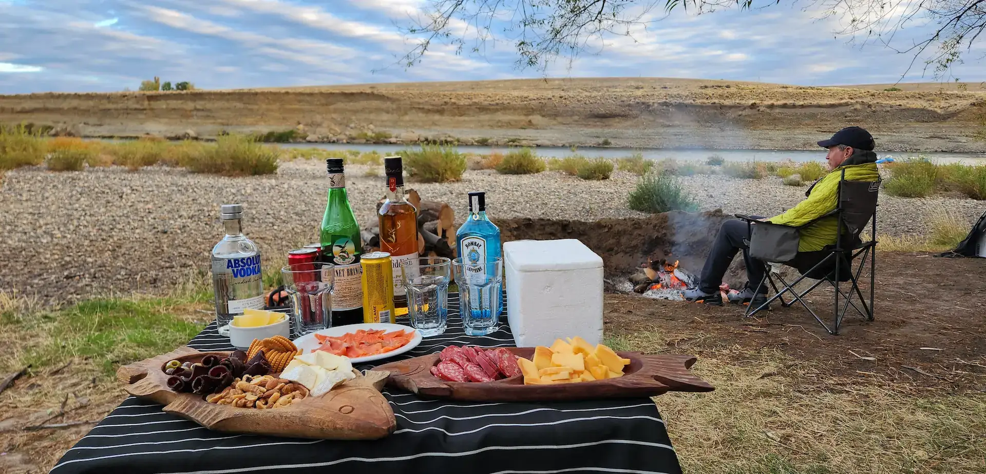 Fly fishing camp trip in Bariloche, Patagonia — relaxing by the Collón Curá River at sunset.